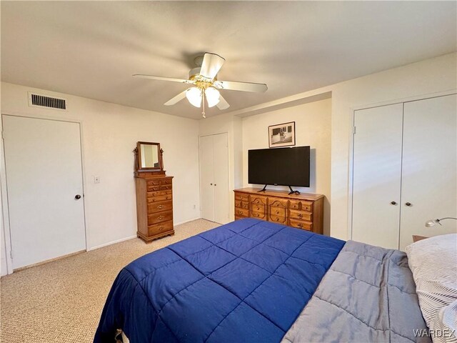 bedroom with a ceiling fan, light colored carpet, and visible vents