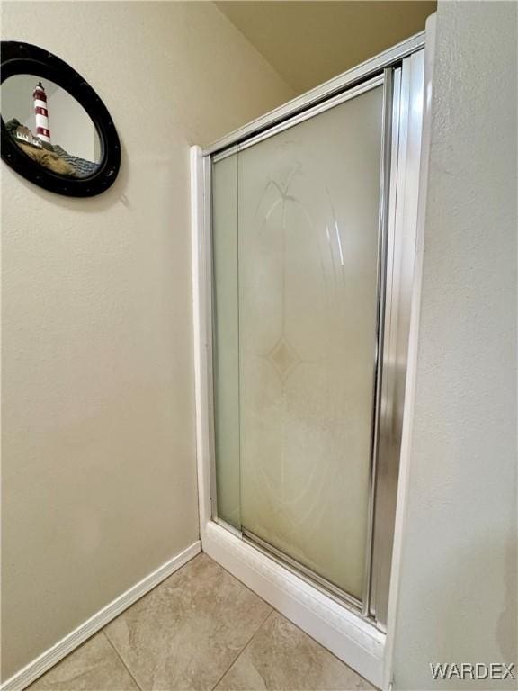 bathroom with tile patterned flooring, baseboards, and a stall shower