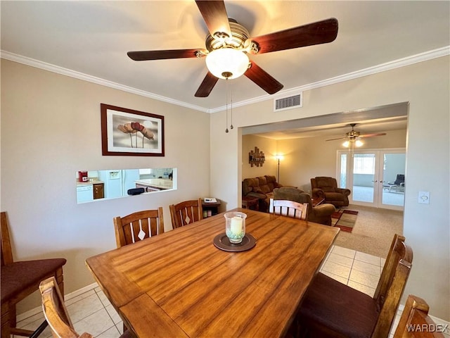 dining room with light tile patterned flooring, french doors, visible vents, and ornamental molding