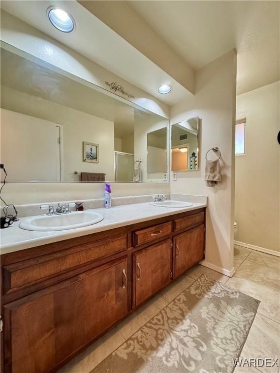 bathroom featuring double vanity, toilet, tile patterned floors, and a sink