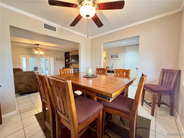 dining room with visible vents, ornamental molding, a ceiling fan, light tile patterned flooring, and baseboards