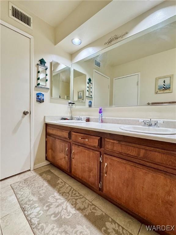 full bath with double vanity, visible vents, tile patterned flooring, and a sink