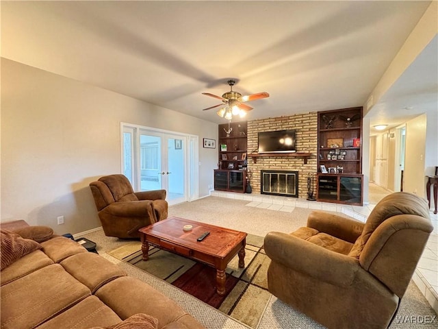 living area with built in features, a ceiling fan, baseboards, french doors, and a brick fireplace