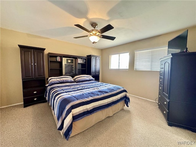 bedroom with light colored carpet, baseboards, and ceiling fan