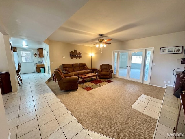 living room featuring light tile patterned floors, french doors, light colored carpet, and ceiling fan