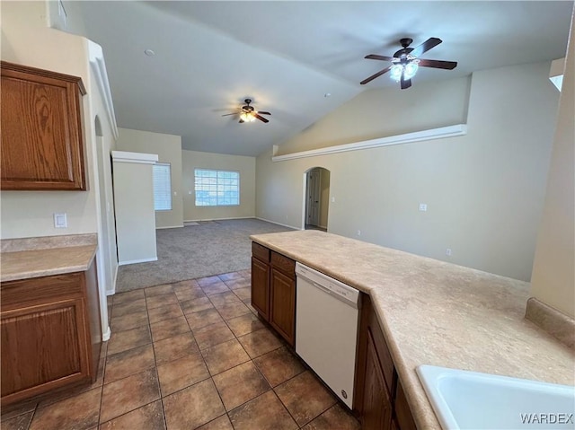 kitchen featuring ceiling fan, white dishwasher, arched walkways, vaulted ceiling, and light countertops