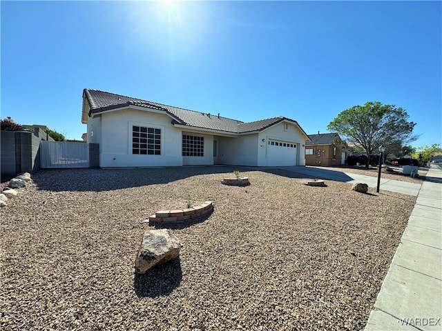ranch-style home featuring fence, a tile roof, a garage, stucco siding, and concrete driveway