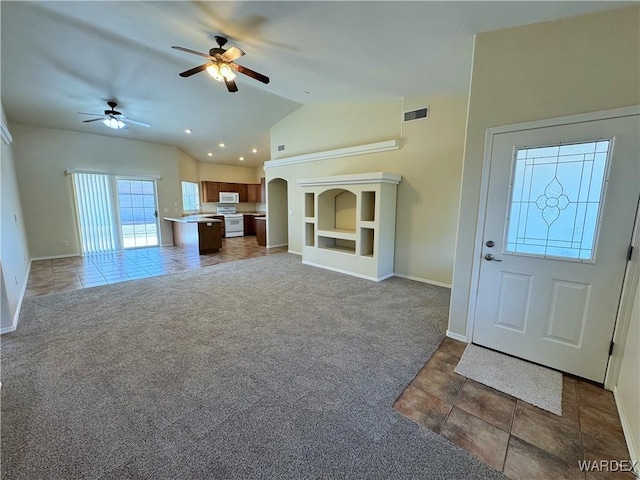 carpeted entryway featuring a ceiling fan, visible vents, tile patterned flooring, baseboards, and lofted ceiling