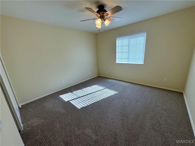 carpeted empty room featuring baseboards and a ceiling fan
