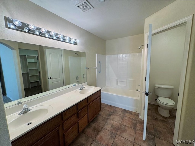 full bath featuring double vanity, toilet, visible vents, and a sink