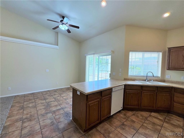 kitchen with ceiling fan, vaulted ceiling, dishwasher, a sink, and light countertops