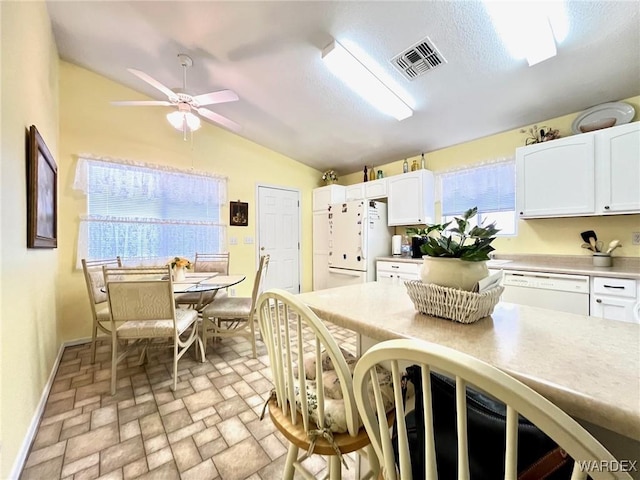 kitchen with white appliances, visible vents, white cabinets, and light countertops