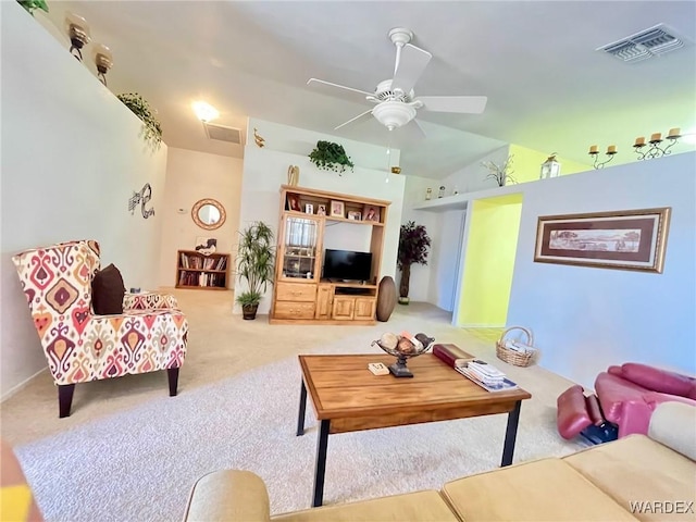 living area with light carpet, visible vents, vaulted ceiling, and a ceiling fan