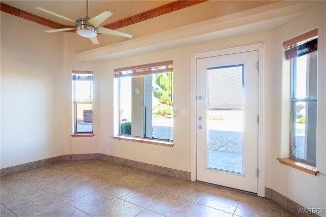 entryway featuring light tile patterned floors, a ceiling fan, and baseboards