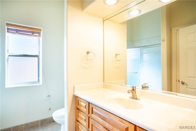 full bath with toilet, vanity, a shower with shower door, and tile patterned floors