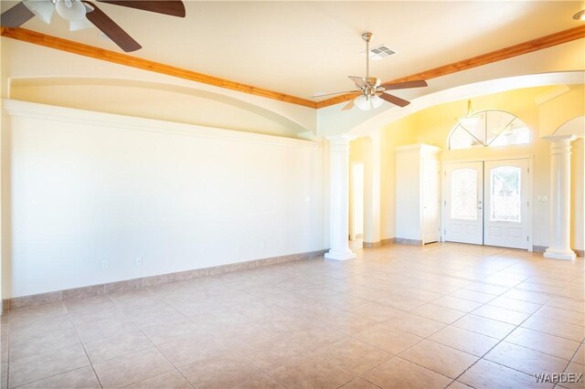 empty room featuring crown molding, ornate columns, visible vents, a ceiling fan, and baseboards