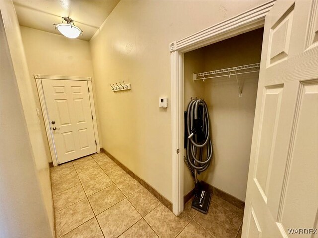 laundry area featuring light tile patterned floors, laundry area, and baseboards