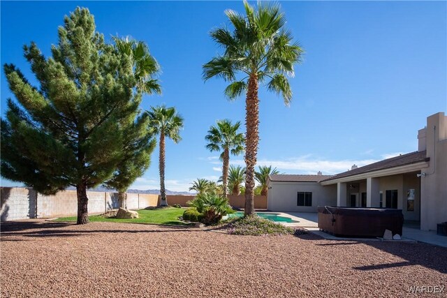 view of yard with a patio, a fenced backyard, and a hot tub