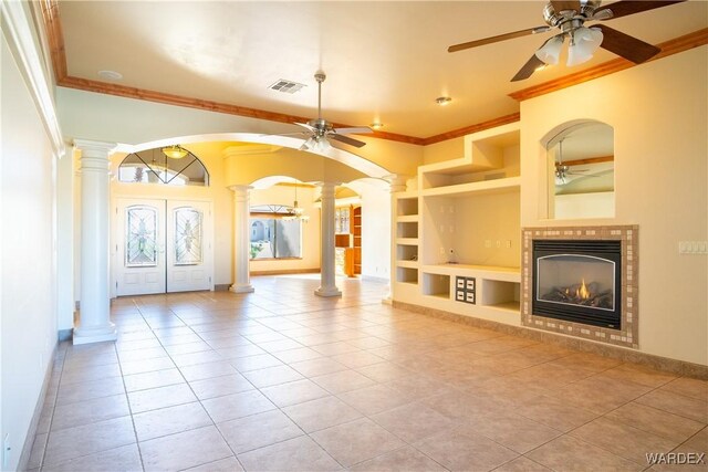 unfurnished living room with arched walkways, built in shelves, visible vents, ornate columns, and crown molding