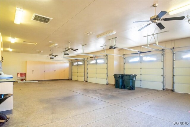 garage with visible vents, a ceiling fan, and a garage door opener