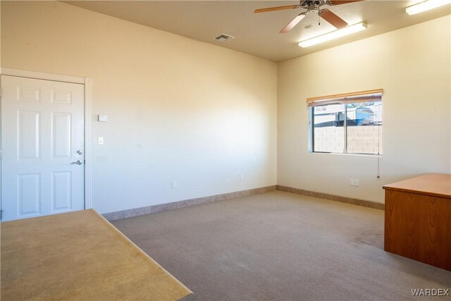 spare room with baseboards, ceiling fan, visible vents, and light colored carpet