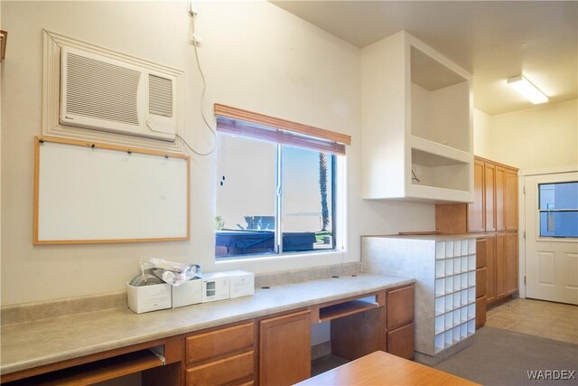 kitchen with brown cabinets, open shelves, light countertops, and a wall mounted AC