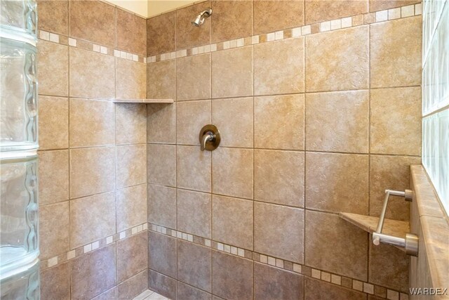 full bath featuring a tile shower