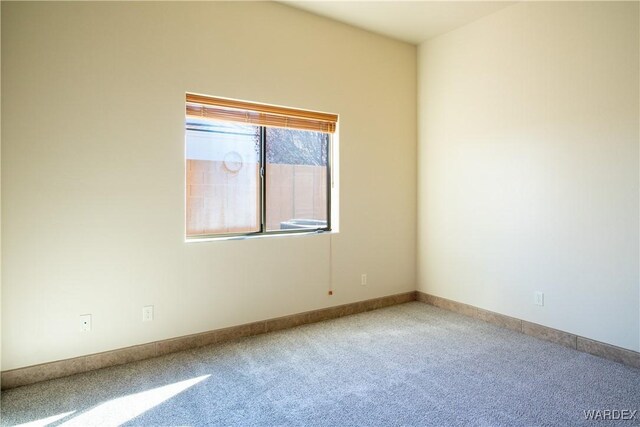 carpeted empty room with baseboards