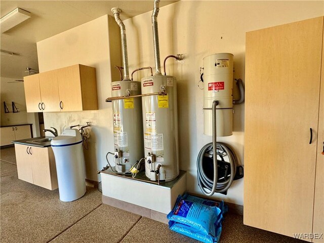 utility room featuring water heater, a sink, and secured water heater