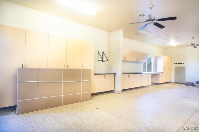 interior space featuring a ceiling fan, visible vents, and light speckled floor