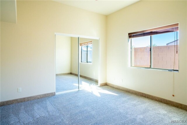 unfurnished bedroom featuring a closet, carpet, and baseboards