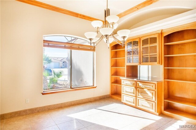 interior space with crown molding, baseboards, light tile patterned flooring, and an inviting chandelier