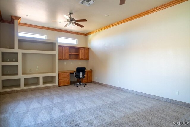 unfurnished office with built in shelves, crown molding, visible vents, light carpet, and built in study area