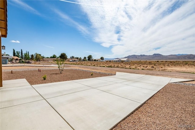 view of yard featuring a patio and a mountain view