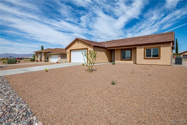 ranch-style house with driveway, a garage, and stucco siding
