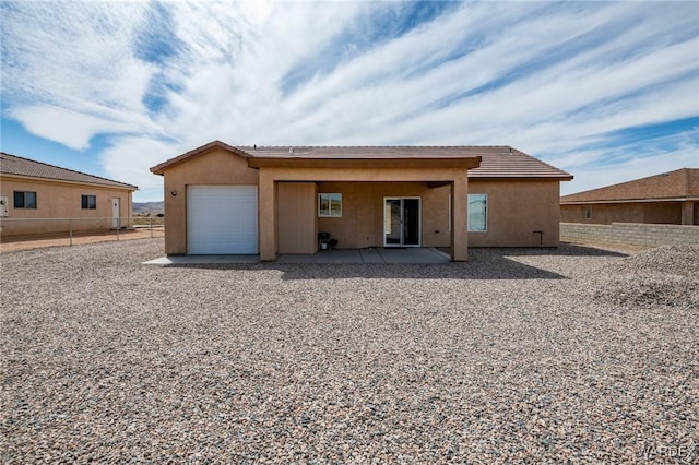 garage featuring fence and driveway