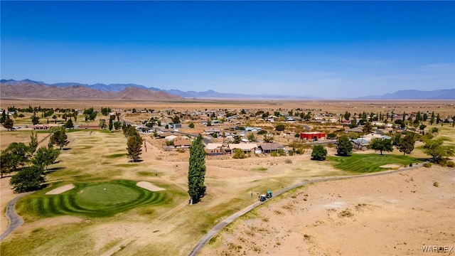 drone / aerial view with view of desert, a mountain view, a residential view, and view of golf course