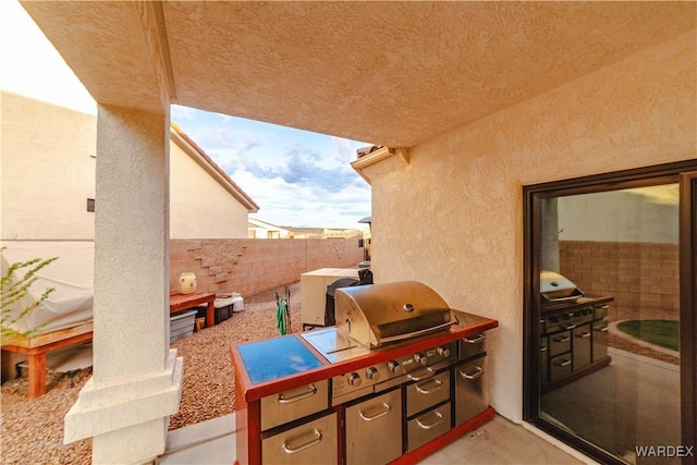 view of patio / terrace featuring an outdoor kitchen and fence