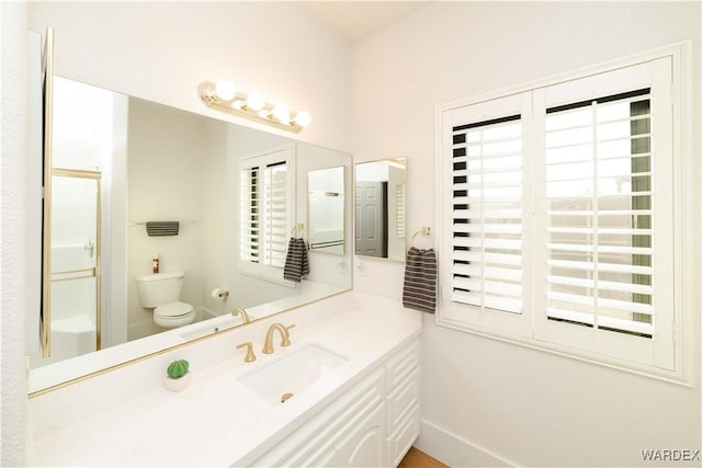 full bath featuring toilet, an enclosed shower, a wealth of natural light, and vanity