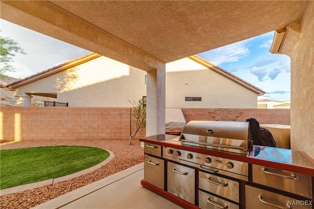 view of patio featuring a fenced backyard, a grill, and exterior kitchen