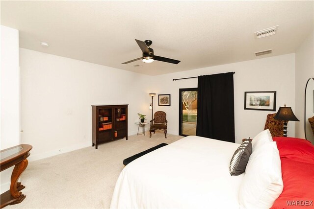 bedroom featuring a ceiling fan, visible vents, and light carpet