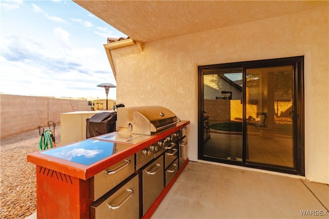 view of patio / terrace featuring fence, an outdoor kitchen, and area for grilling