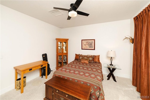 bedroom featuring light carpet, ceiling fan, visible vents, and baseboards