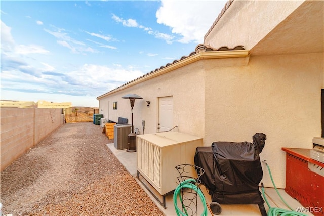 exterior space with a fenced backyard, central AC, and stucco siding