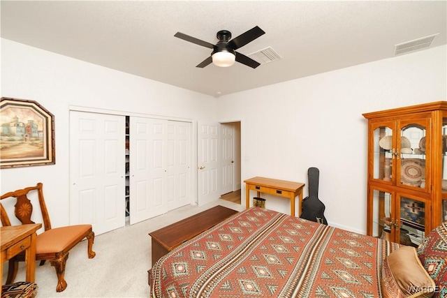 bedroom with ceiling fan, a closet, visible vents, and light colored carpet