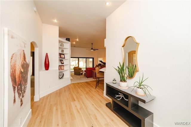 hall featuring arched walkways, wood finished floors, and recessed lighting