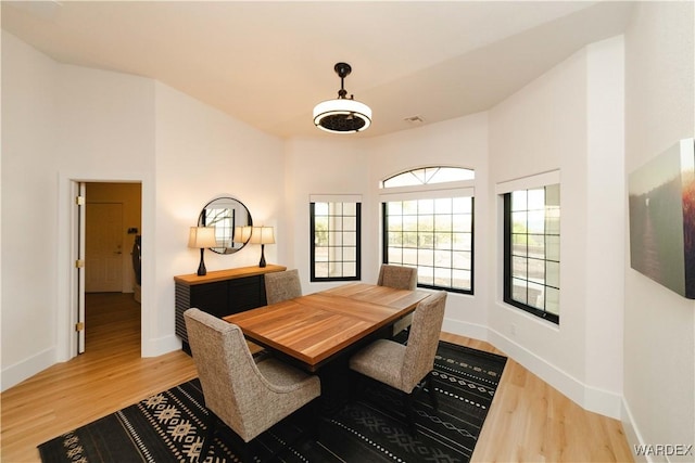 dining space featuring visible vents, baseboards, and wood finished floors