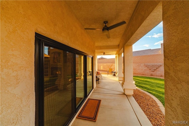 view of patio featuring ceiling fan and fence