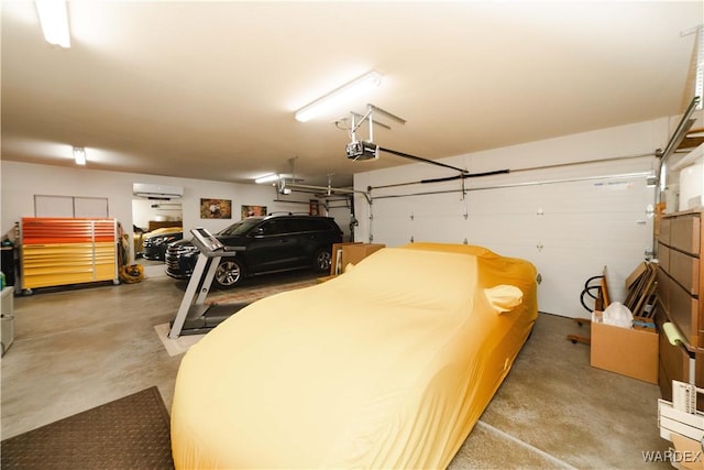 garage with an AC wall unit and a garage door opener