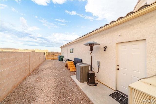 exterior space featuring a patio area, a fenced backyard, central AC, and stucco siding